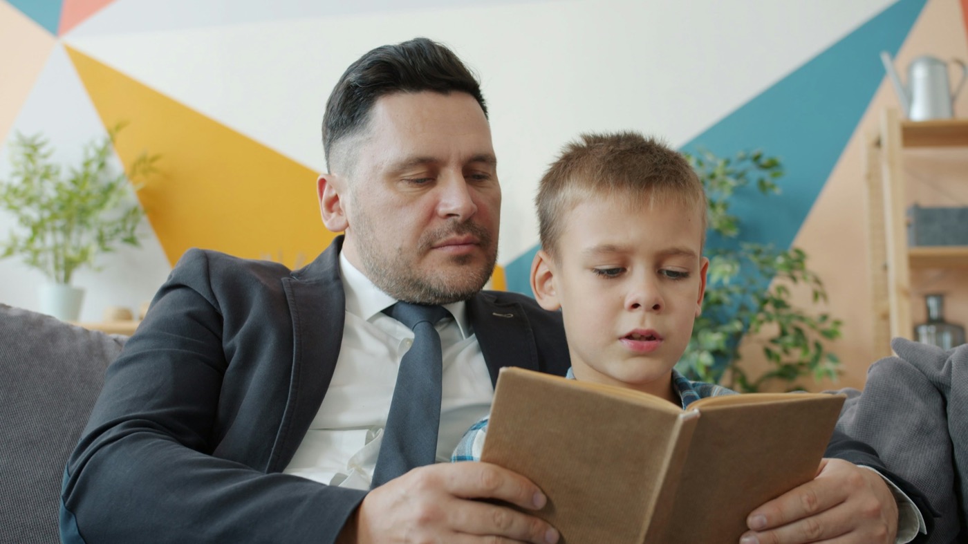 A dad reading a book with his son